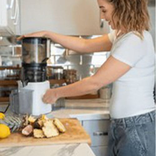 Woman using blender in kitchen
