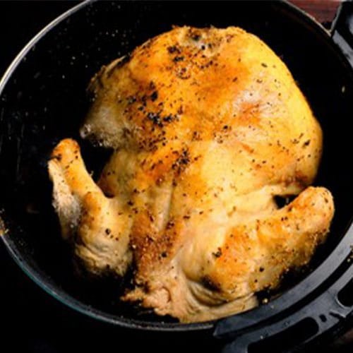Top view of brown, roasted chicken and air fryer. Healthy eating_